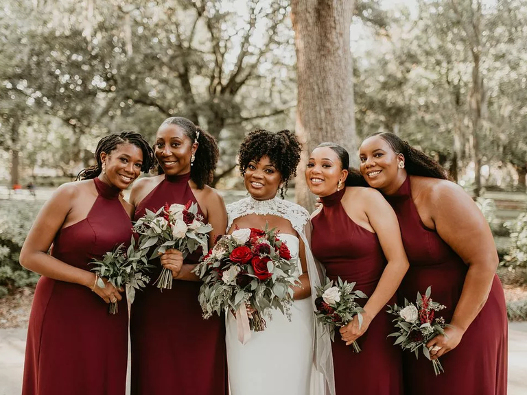 Bride with bridesmaids in matching burgundy dresses.