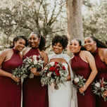 Bride with bridesmaids in matching burgundy dresses.