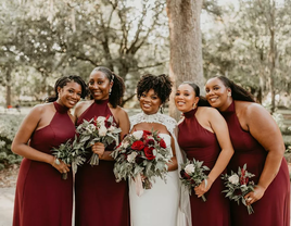 Bride with bridesmaids in matching burgundy dresses.