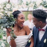 bride and groom smiling each other outside