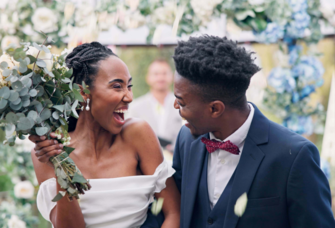 bride and groom smiling each other outside