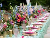 long wedding reception table with colorful centerpieces down the middle