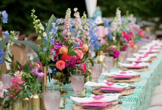 long wedding reception table with colorful centerpieces down the middle