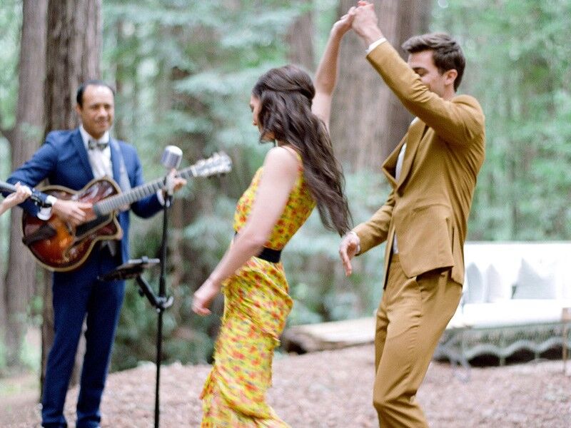 Couple dancing in the forrest with a live band after their engagement