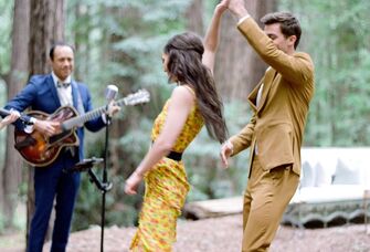 Couple dancing in the forrest with a live band after their engagement