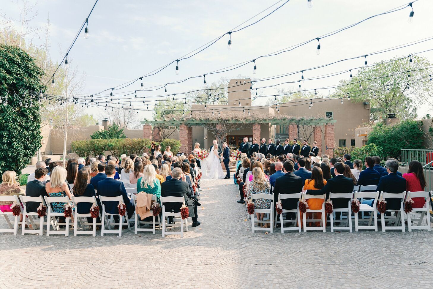 Outside ceremony with guests sitting down on each side of the aisle