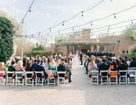 Outside ceremony with guests sitting down on each side of the aisle