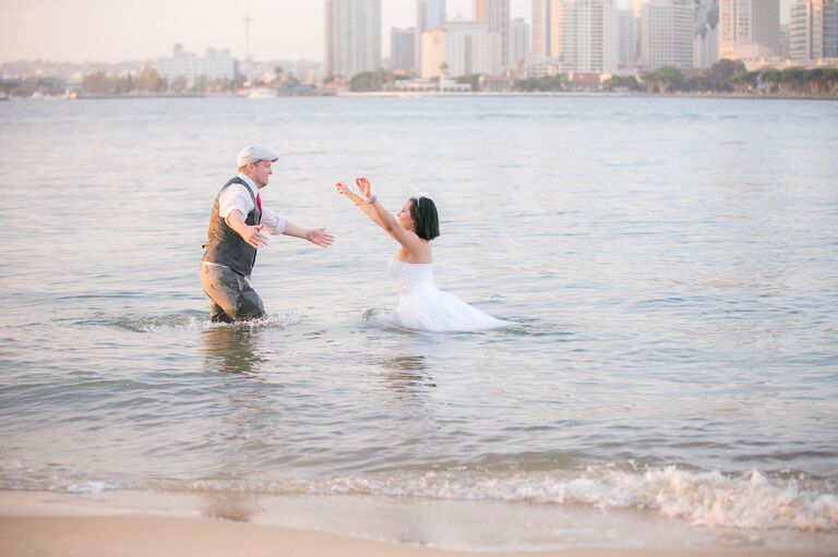 Bride running toward groom in the water