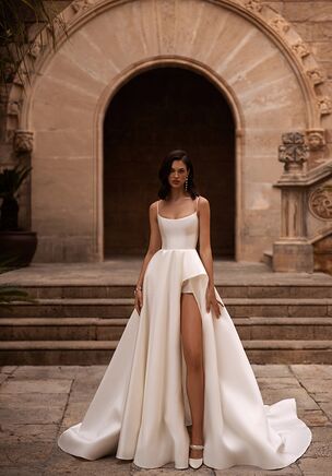 Ignite the atmosphere with our mesmerizing A-line wedding dress, a true embodiment of glamour and allure. Crafted from luxurious glossy fabric, this dress exudes an irresistible charm that captivates all eyes. The corset, delicately placed on straps, offers a perfect balance of support and grace, highlighting your natural beauty. The showstopper, however, lies in the asymmetrical skirt design, which artfully showcases your leg, adding an element of unexpected allure to your bridal ensemble. With every step, you radiate confidence and elegance, leaving an indelible impression on all who witness your entrance. Let this A-line wedding dress be the embodiment of your unique style and ignite the spirit of adventure as you embark on your journey of love.
