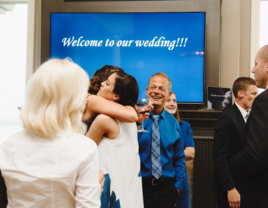 Bride and guests embracing at a surprise wedding