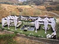 Open-air reception structure with white draping for glam wedding