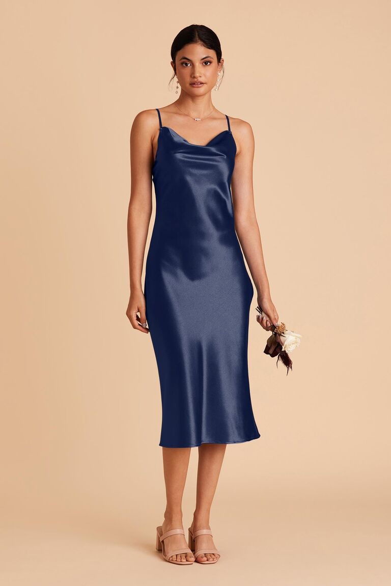 Model wears a navy blue satin gown. 