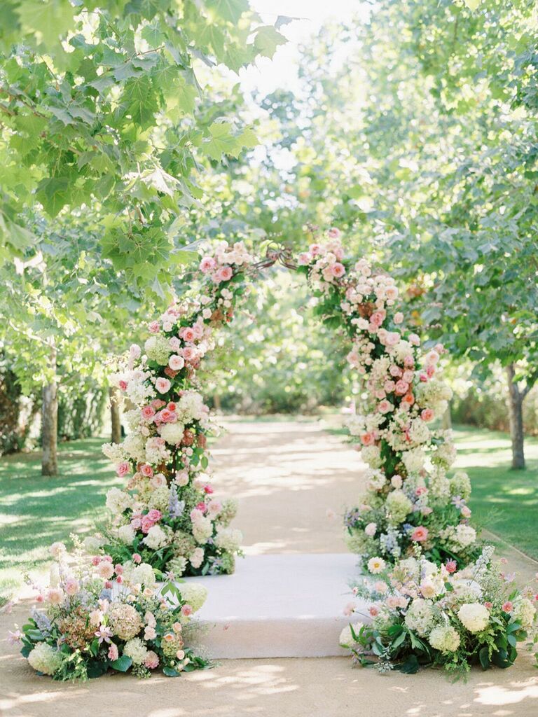 Garden arch covered in pink roses and white hydrangea