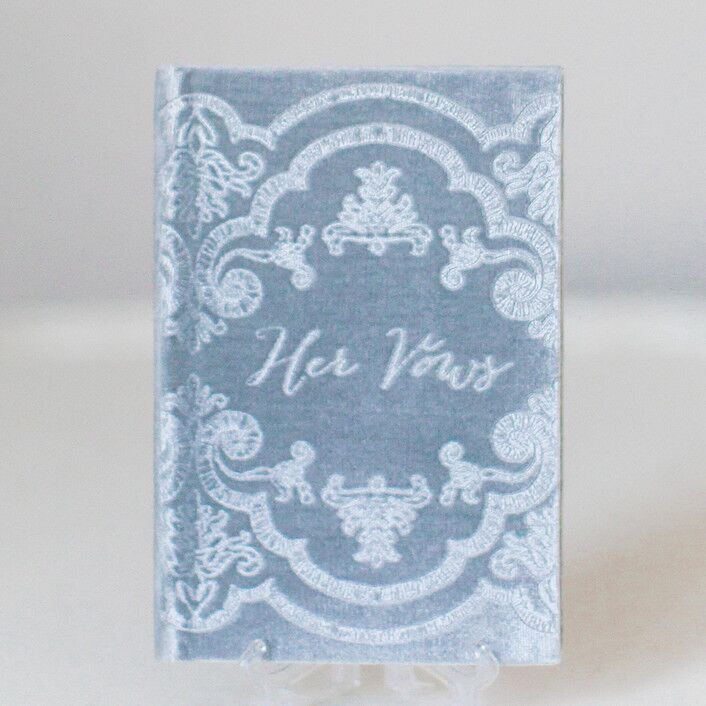 blue velvet vow book with ornate antique scroll design on the cover