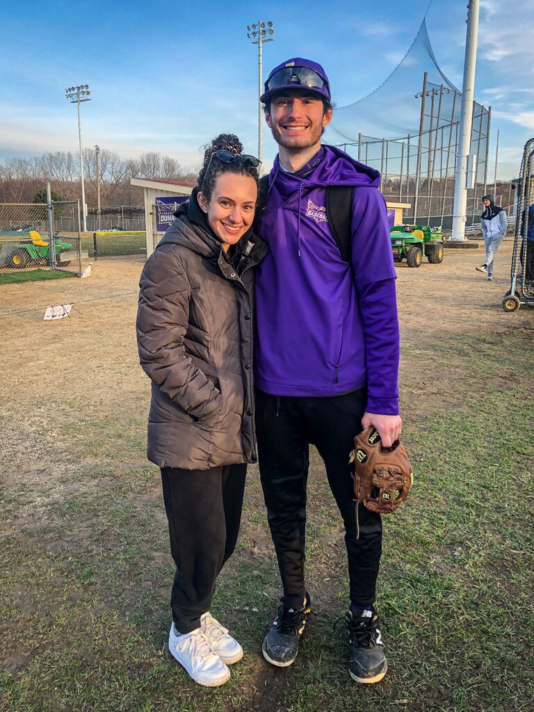 Abby watching Owen play baseball for Loras