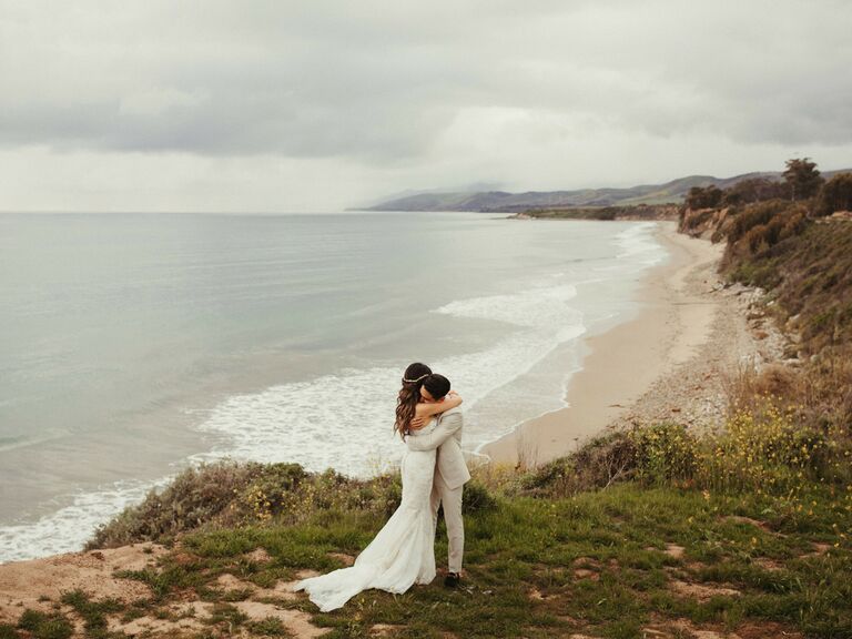 Friluftsliv wedding couple hugging on beach coastline