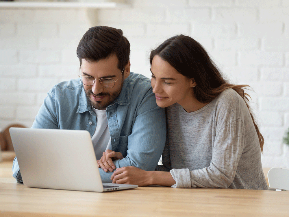 Couple smiling while on wedding website after the wedding.