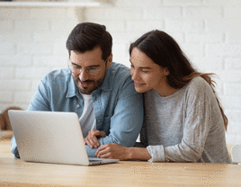 Couple smiling while on wedding website after the wedding.