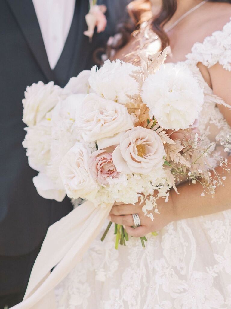 Bride holding white bouquet on wedding day 