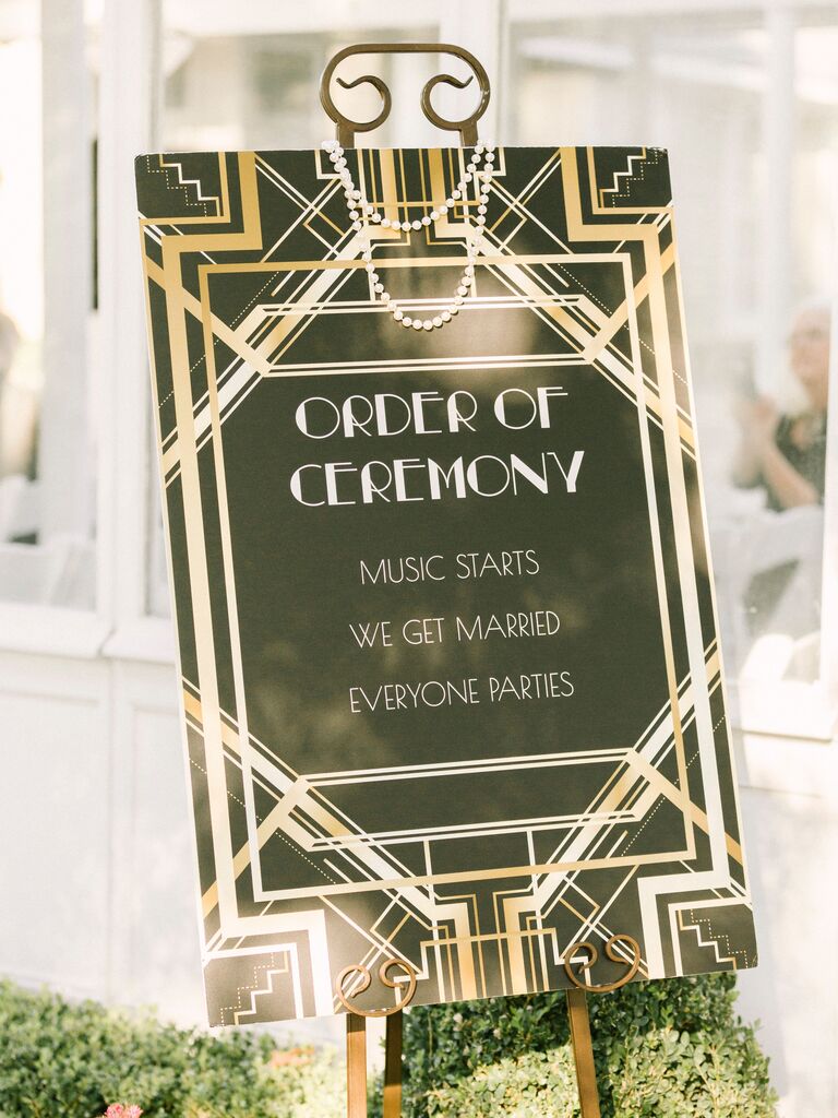 art deco themed ceremony sign that says music starts, we get married, everyone parties
