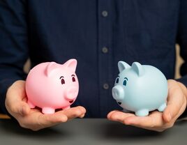 Man holding a pink and blue piggy bank