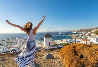 Happy woman looking over the beautiful city of Greece