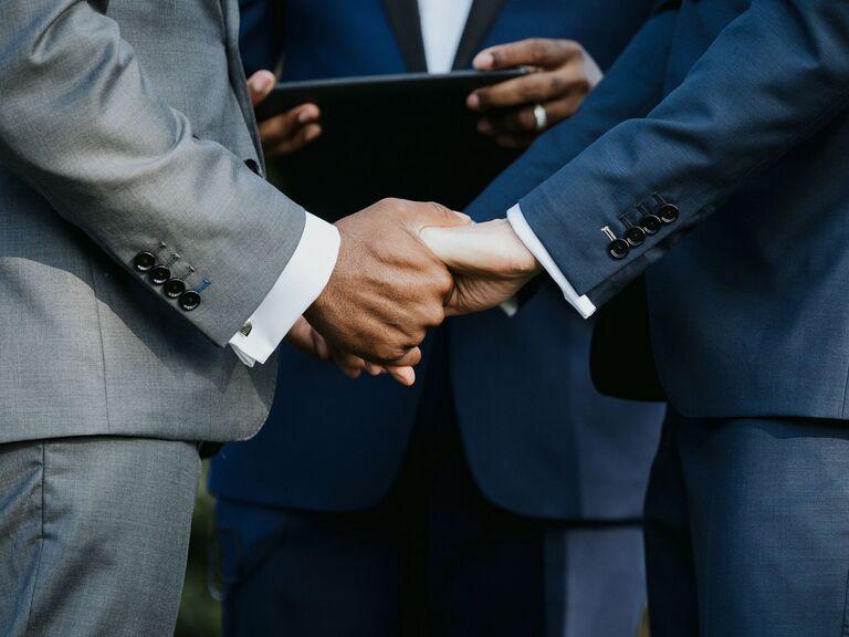 Couple holding hands during wedding ceremony.