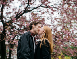 Couple kissing under cherry blossom trees