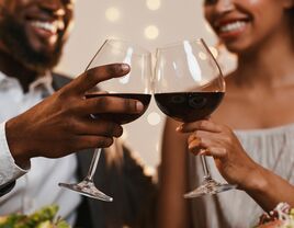 Couple toasting glasses of red wine