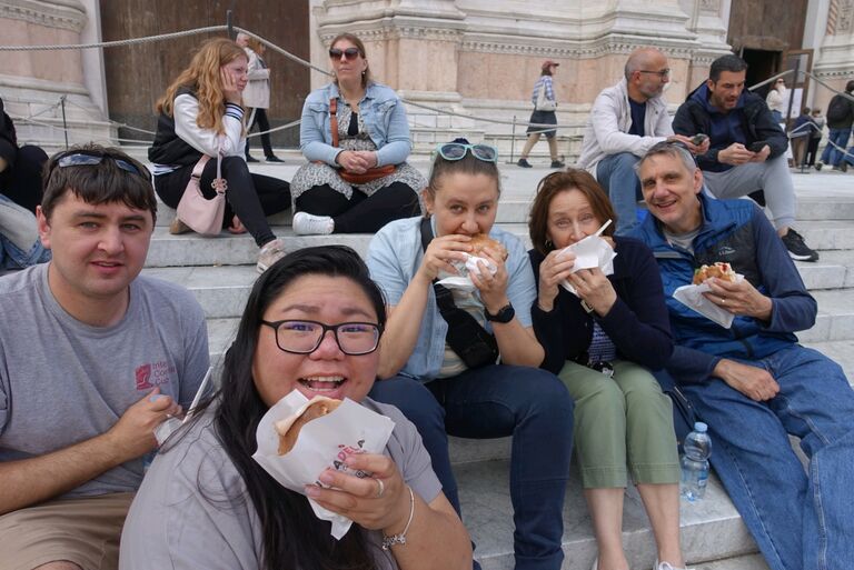Munching on Mortadella sandwiches on the church steps in Bologna, Italy
