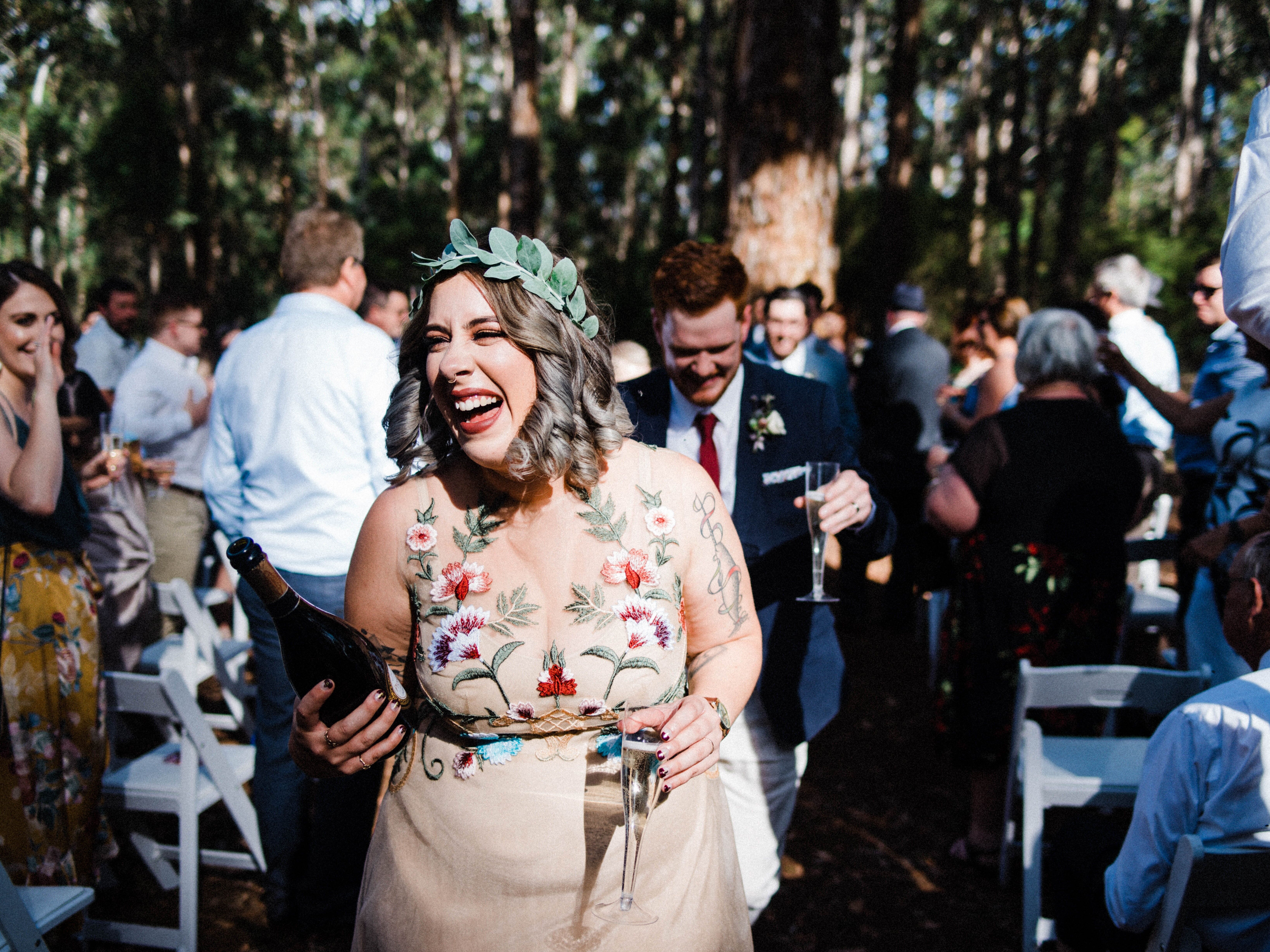 Happy guests walking down the aisle with a bottle of champagne