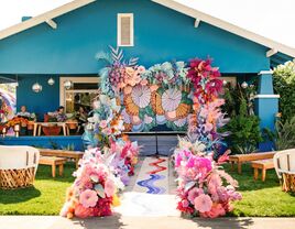 Colorful aisle runner in front of a blue house. 