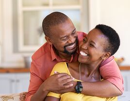 Couple hugging each other and smiling.