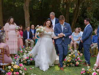 A bride and groom walk hand and hand down the aisle in their wedding recessional