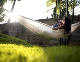 Couple relaxes in a hammock together. 