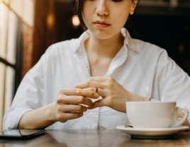 Woman thinking while holding wedding ring