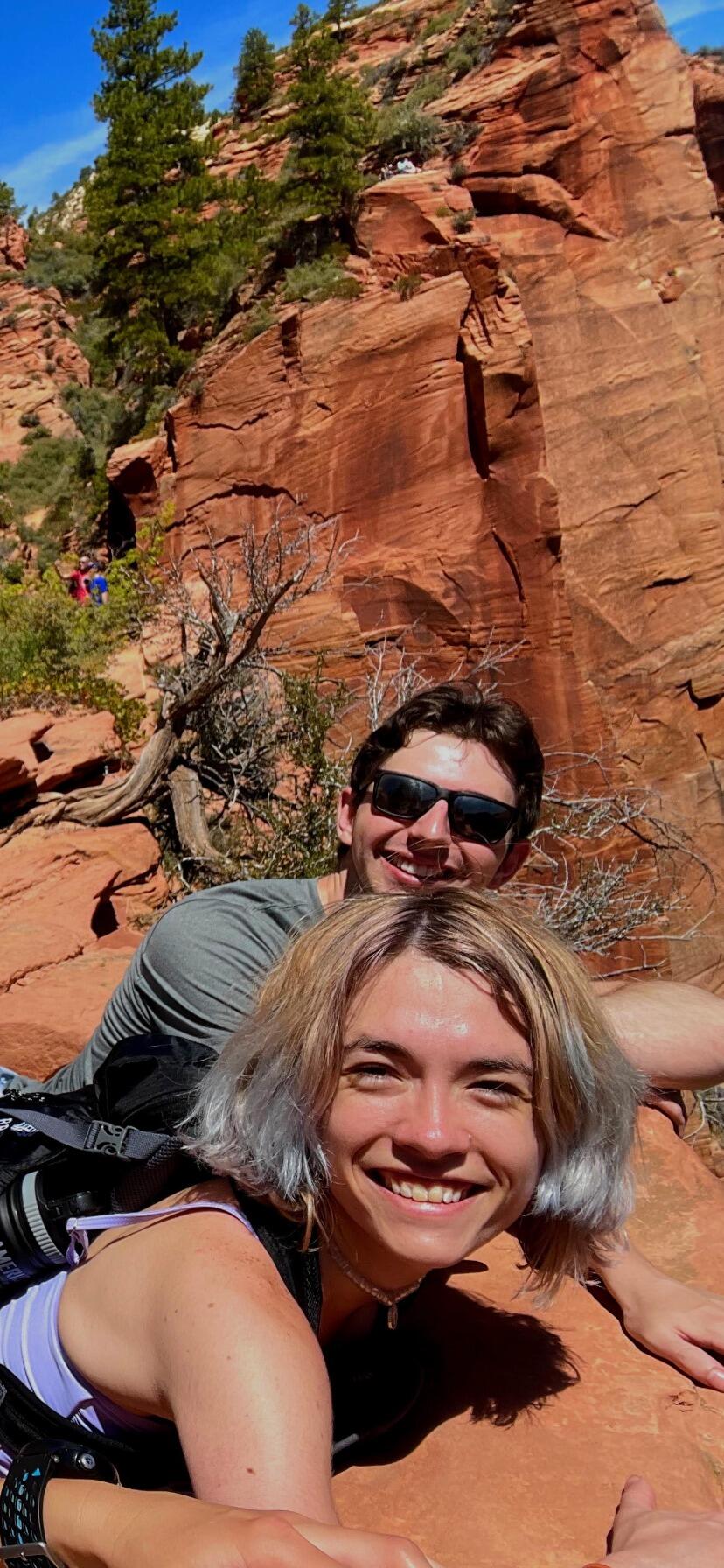 Ben and Katlyn peering over the cliff at Zion National Park on the hike up Angel's Landing, admiring the views.