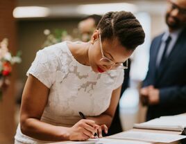 Bride signs a marriage license.