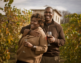 Couple drinking wine in field in Missouri