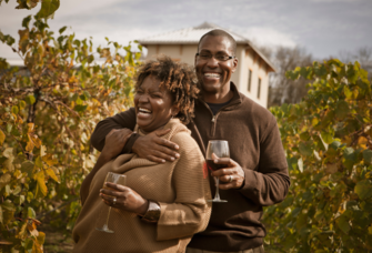 Couple drinking wine in field in Missouri