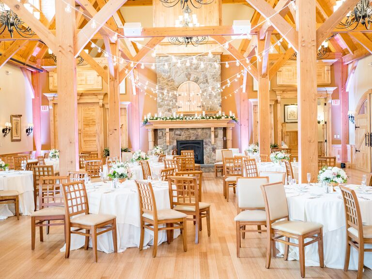 Bright barn venue with large stone fireplace and wooden beaming