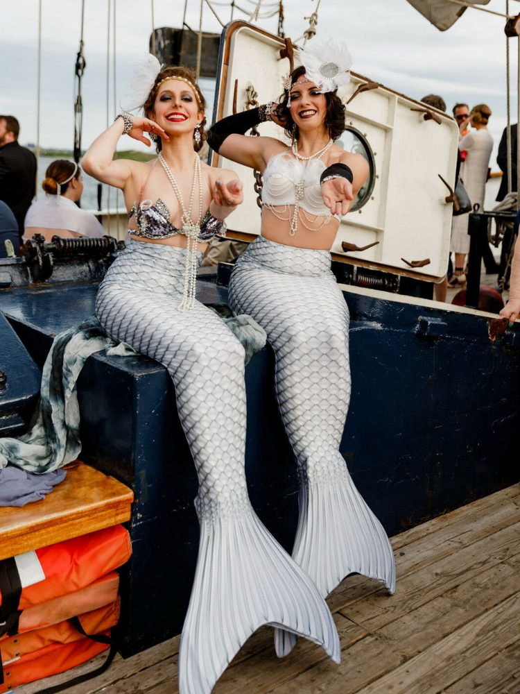 Performers dressed as mermaids on boat