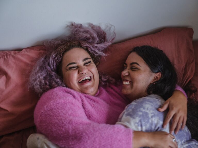 Two women cuddle and laugh together