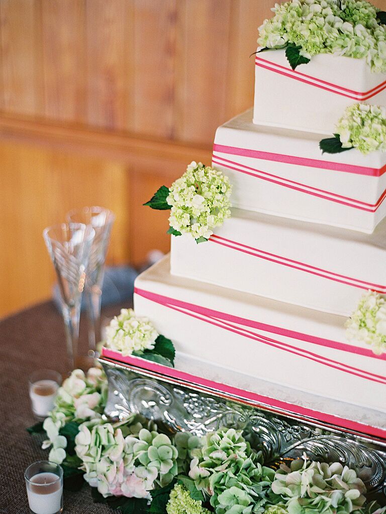 Four-tiered, white wedding cake with pink pattern