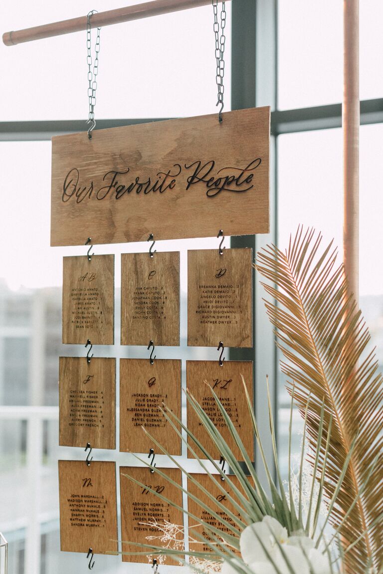 Laser-cut wood seating chart hanging from copper frame