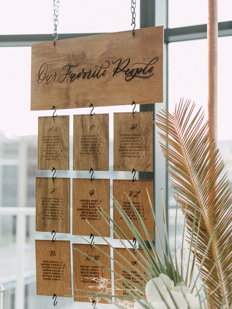 Laser-cut wood seating chart hanging from copper frame