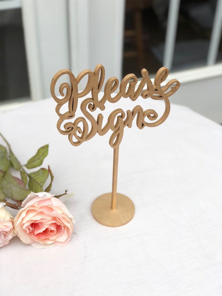 'Please sign' wood cut out in loopy script