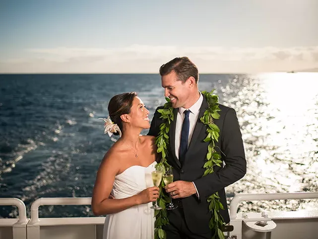 Couple smiling with each other with champagne glasses on Majestic by Atlantis Cruises