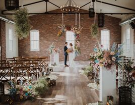 Couple at the top of the altar in the floral decorated ceremony space