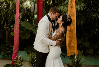 Bride and groom in front of Balinese flags on wedding day